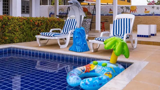 Piscina com espreguiçadeiras e brinquedos aquáticos