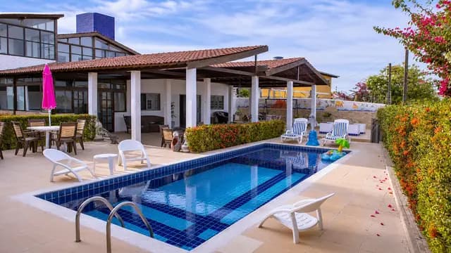 Vista ampla da piscina e dos ambientes externos da casa