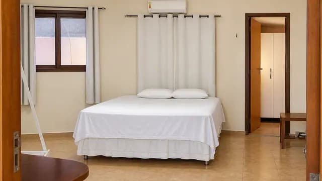 Quarto amplo com cama e janelas