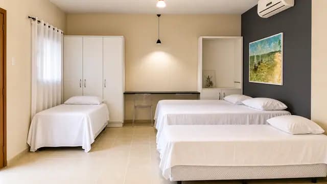 Ambiente amplo de suíte com diferentes camas