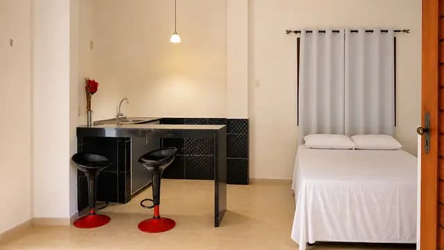 Quarto com cama, bancada e banquetas